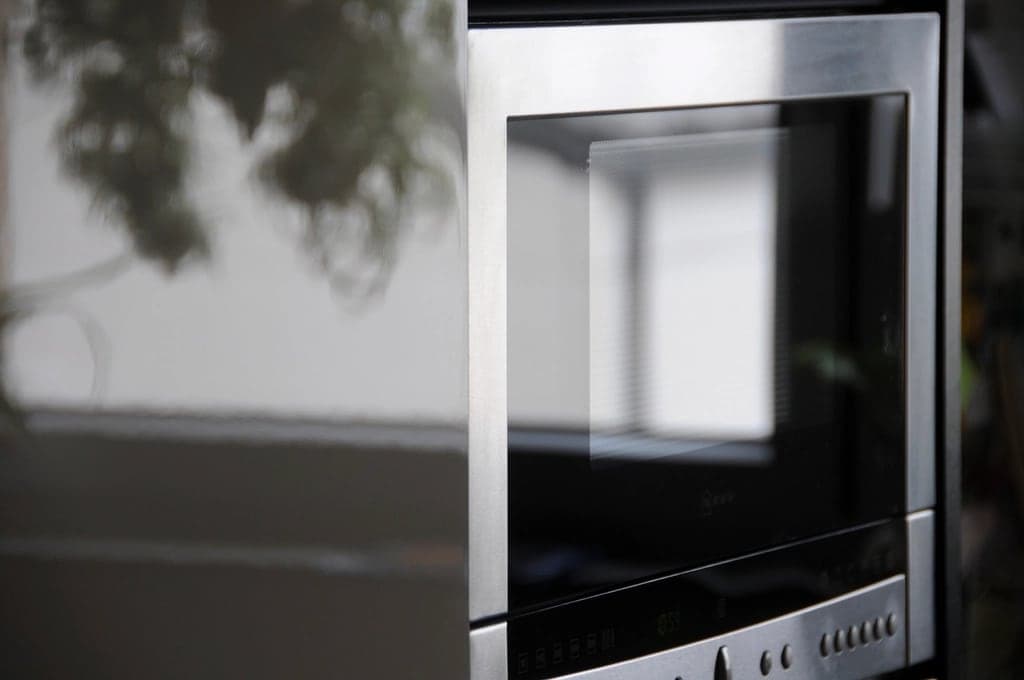 Detalhe da porta de um micro-ondas de inox